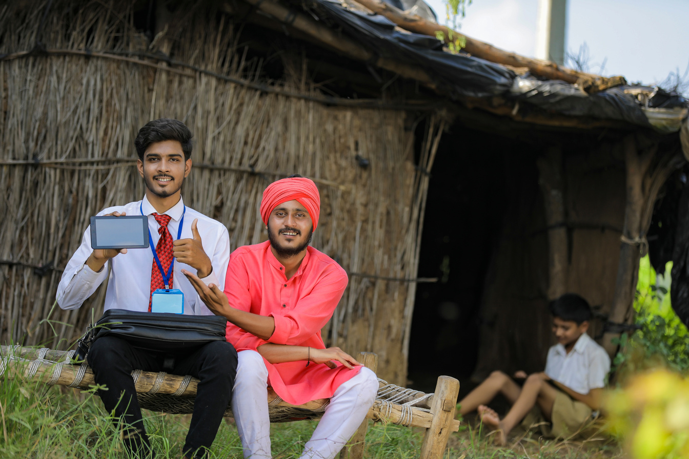 Young Indian bank officer showing mobile screen with farmer